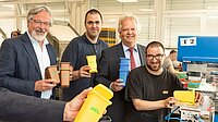 Lebenshilfe-Geschäftsführer Stefan Pauls (links) überreicht mit den Werkstattmitarbeitern Maurizio Dâ'Angelo (2.v.l.) und Stefan Stein (r.) die Minimülltonnen an AWG-Geschäftsführer Martin Bickenbach (2.v.r.). Foto: AWG