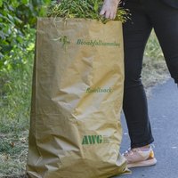 Bio-Beistellsack der AWG aus Papier mit Grünschnitt befüllt.