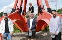 Die vier neuen Auszubildenden der AWG an einem ausgedienten Müllgreifer vor dem Müllheizkraftwerk auf Korzert: Abdelmalek Agaddu (links), David Mayer (Mitte vorn), Marissa Schaper (Mitte hinten) und Oguzhan Halatli (rechts). 